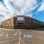 Exterior of a large brown and tan charter school facility