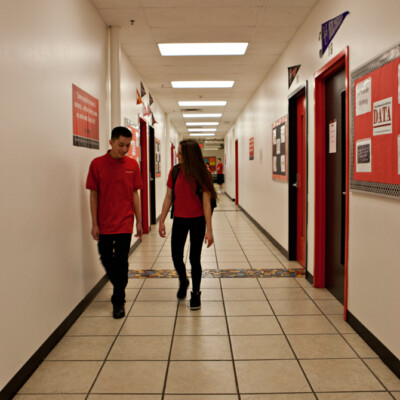 Two students walking down school hallway
