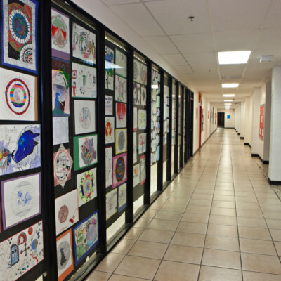 A long white school hallway with student art hanging on the walls