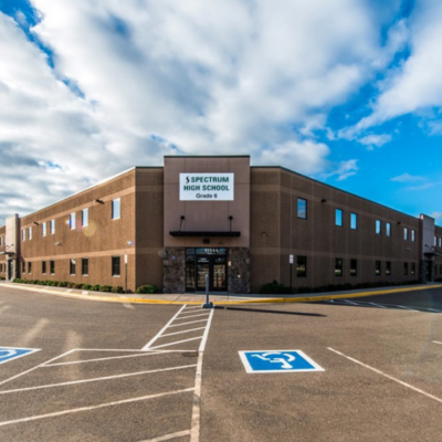 Exterior of a large brown and tan charter school facility