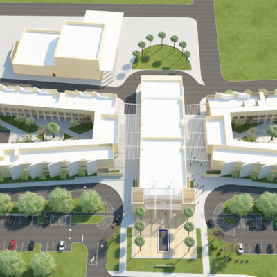 An aerial view of a large white charter school facility surrounded by grass and palm trees