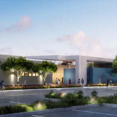 Students and parents walking down a sidewalk framing the Norton Science and Language Academy charter school facility