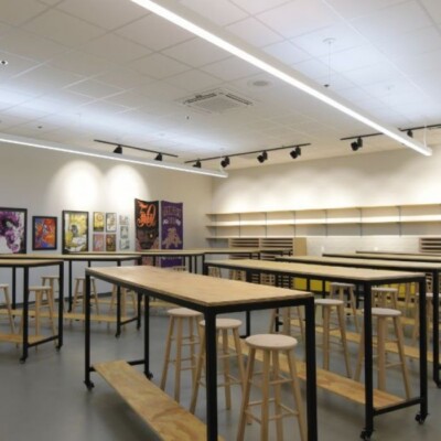 A science lab with work benches and stools and posters on the wall
