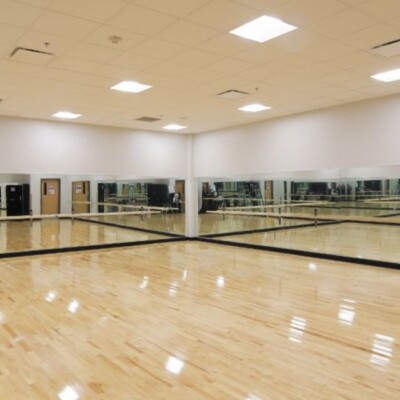 A large dance room with mirrored walls located in the Young Audiences Charter School building