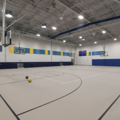 A gym with basketball hoops the new Young Audiences Charter School facility